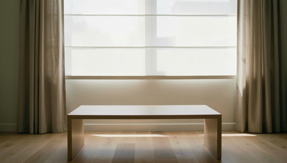 Fenêtre à voilage avec une table basse épurée, aucun appareil visible, lumière douce du matin
